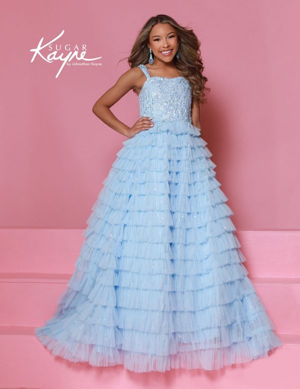 A young girl wearing a light blue ruffle pageant gown with sequin bodice and tiered tulle skirt by sugar kayne.